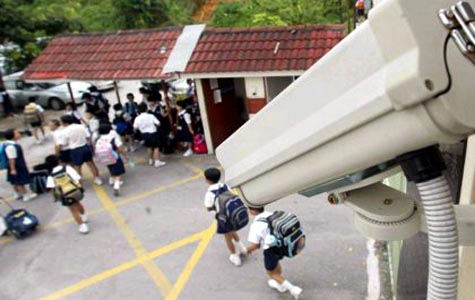 School security camera monitoring students entering the building. CCTV camera installed at school entrance for student safety and security.