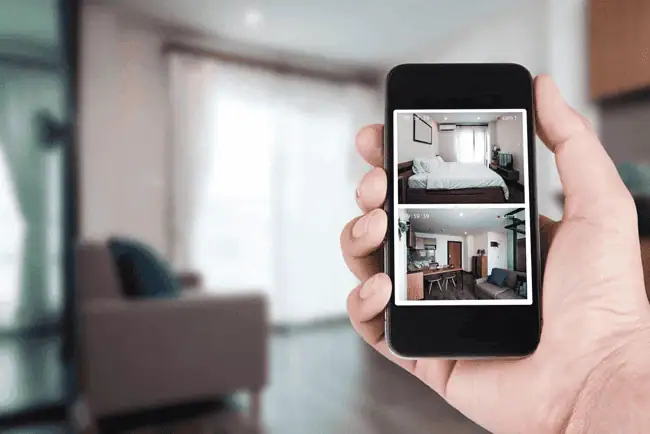 Smartphone displaying live CCTV footage of home interior.