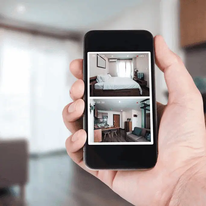 Smartphone displaying live CCTV footage of home interior.