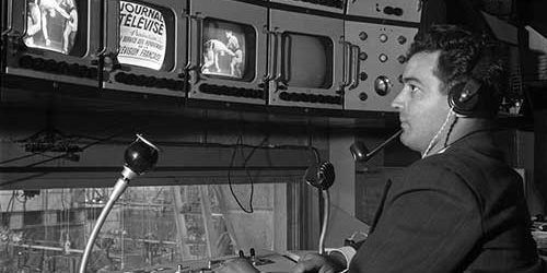 CCTV operator monitoring multiple screens in a control room.
