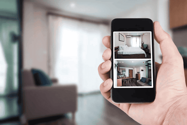 Smartphone displaying live CCTV footage of home interior.