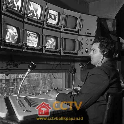 CCTV operator monitoring multiple screens in a control room.